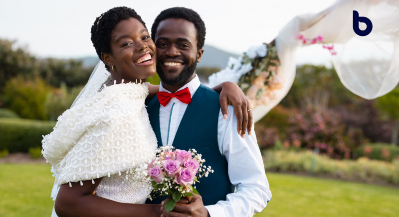 Joyful newlywed couple posing outdoors, smiling at the camera, with a bright future ahead, learning the 13 must-know smart investment tips to build a secure and prosperous life together