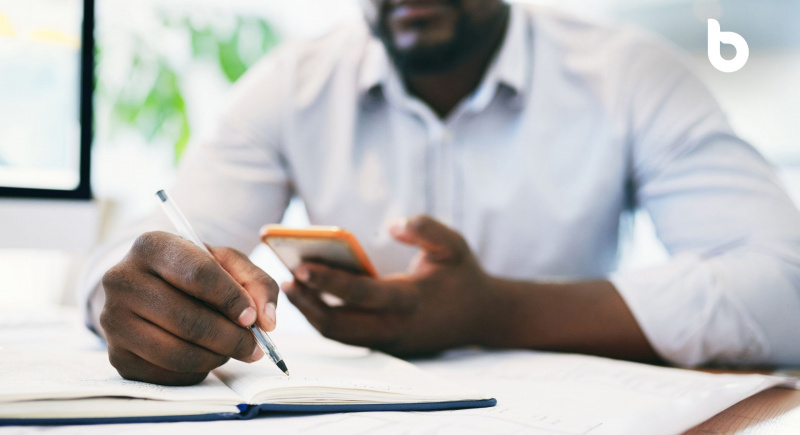 Image of a black man reviewing his budget on a mobile phone, symbolizing regular review and adjustment to make your salary last longer.