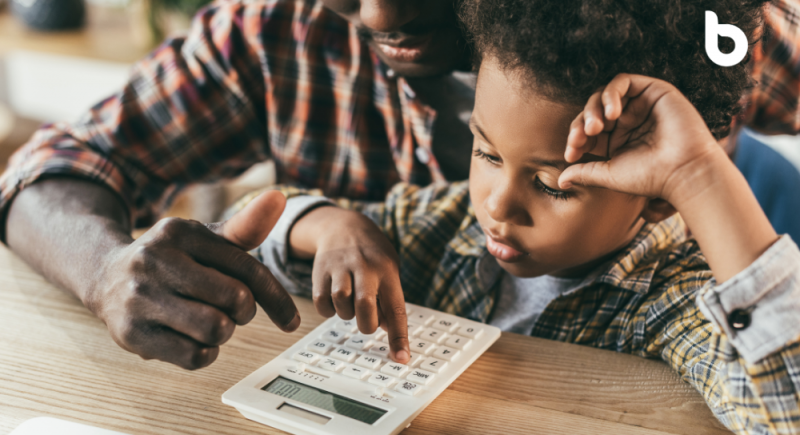 Close-up shot of a middle-aged father and his child doing some calculations and echoing the message "Teach your child about money"