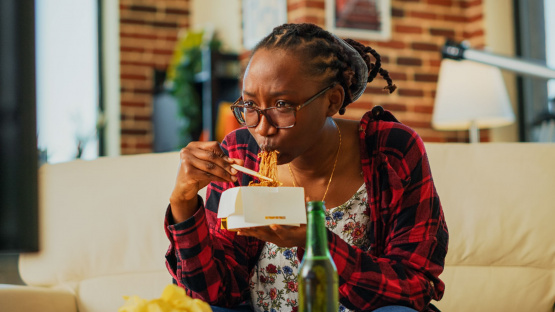 Woman with takeout, illustrating the need for mindful spending in money hacks to improve your finances