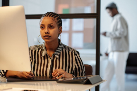 Professional woman calculating taxes at her office desk, impacted by Nigeria's proposed tax bill